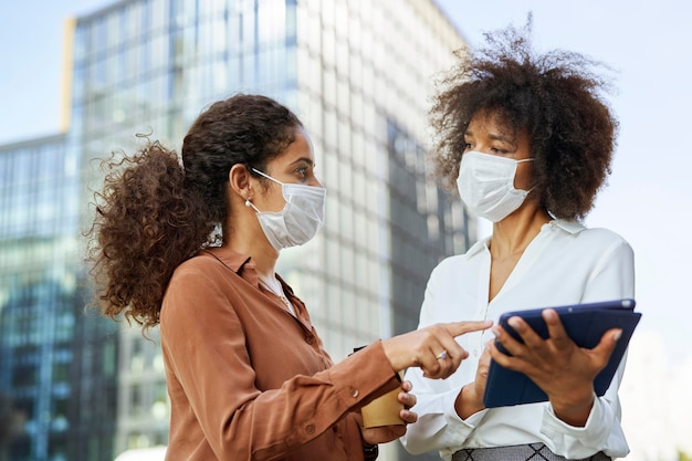 Dos empresarias con mascarillas en la ciudad.