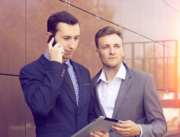 Dos empresario mirando tableta. El éxito del trabajo de los profesionales.