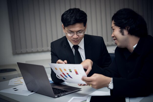 Dos empresarios asiáticos discuten sobre los negocios de la empresa. Dos personas hablan sobre el estrés laboral y algo más serio.