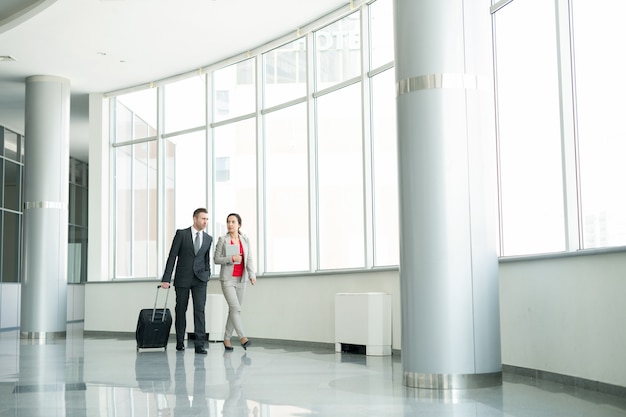 Dos empresarios caminando a la puerta en el aeropuerto