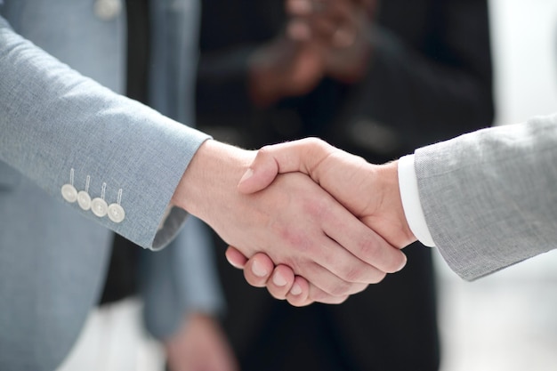 Dos empresarios de confianza dándose la mano durante una reunión en el éxito de la oficina y el concepto de socio