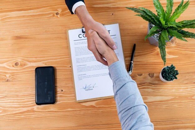 Foto dos empresarios dan la mano después de firmar con éxito el contrato entidad