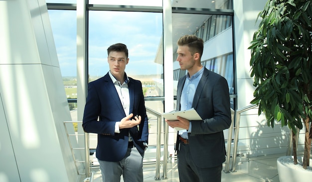 Dos empresarios discutiendo negocios en la oficina.