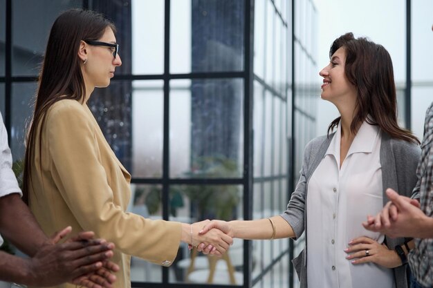 Foto dos empresarios profesionales dándose la mano en el vestíbulo de una oficina