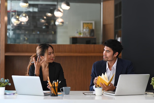 Dos empresarios profesionales discutiendo sobre la planificación de la estrategia de marketing en la oficina moderna