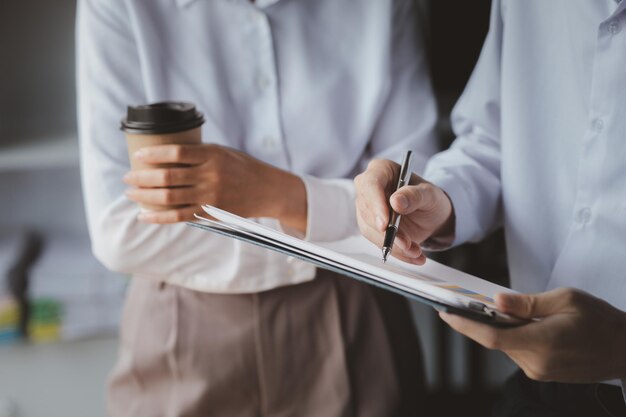 Dos empresarios señalaron el material de la reunión trabajando juntos para planificar el desarrollo y la solución de problemas empresariales comunes Concepto de gestión empresarial para el crecimiento y la calidad