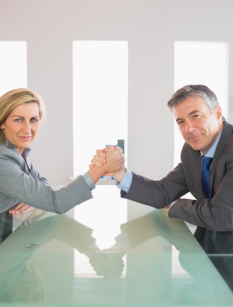 Foto dos empresarios sonrientes con un enfrentamiento sentados alrededor de una mesa