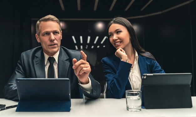 Los dos empresarios sonrientes sentados en la mesa