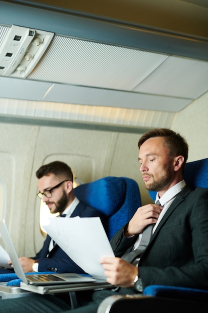 Dos empresarios trabajando en avión