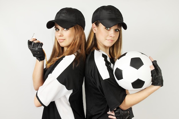 Dos entrenadores de fútbol con el balón y el silbato.