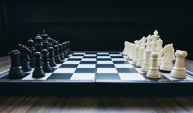 Dos equipos de ajedrez frente a diferentes colores blanco y negro en el tablero de ajedrez