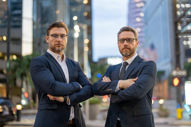 Los dos equipos de negocios trabajaron juntos para lograr sus objetivos, los hombres de negocios cruzaron los brazos al aire libre jóvenes