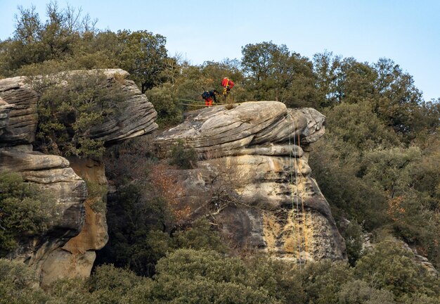 Dos escaladores preparándose para descender en rappel por un desfiladero con cuerdas preparadas