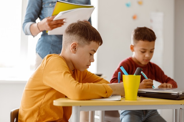 Dos escolares durante una lección y una prueba en la escuela.