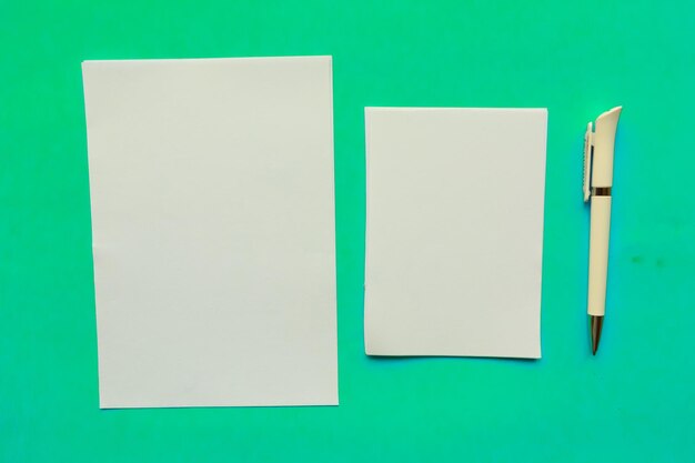 Dos espacios en blanco de maqueta y bolígrafo sobre fondo azul Espacio de copia de vista superior plana