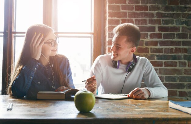 Dos estudiantes adolescentes sentados en el escritorio y charlando antes de la lección