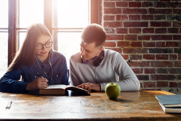 Dos estudiantes adolescentes sentados en el escritorio y preparándose para la lección