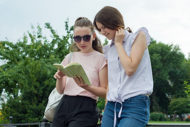 Dos estudiantes de aprendizaje niñas con mochilas al aire libre