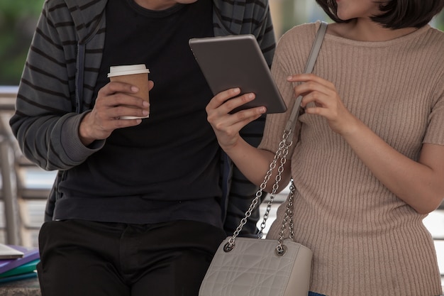 Foto dos estudiantes que estudian con el cuaderno de computadora al aire libre