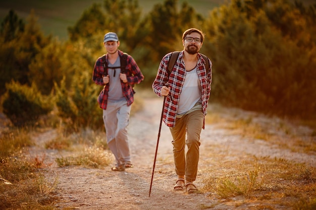 Dos excursionistas disfrutan de un paseo por la naturaleza al atardecer en verano