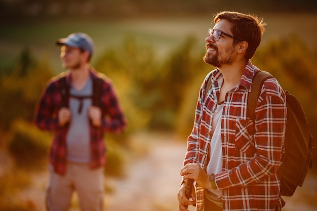 Dos excursionistas disfrutan de un paseo por la naturaleza al atardecer en verano