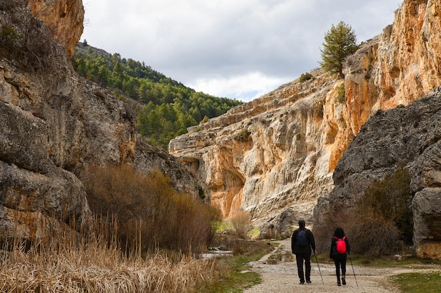 Dos excursionistas escalando un sendero de montaña