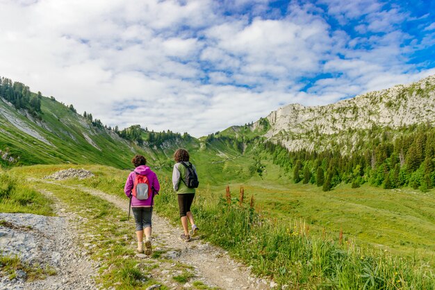 Dos excursionistas mujeres caminando en las montañas