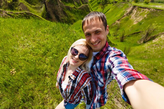 Dos excursionistas tomándose selfie en la cima de la montaña