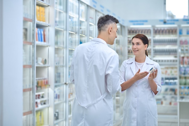 Dos farmacéuticos discutiendo la medicación en farmacia