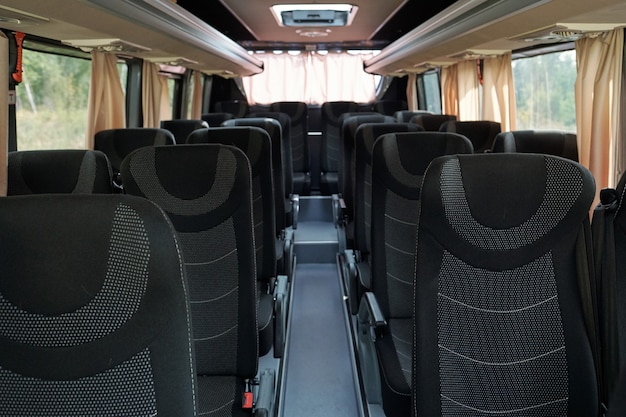 Dos filas de asientos dobles grises y negros dentro del autobús