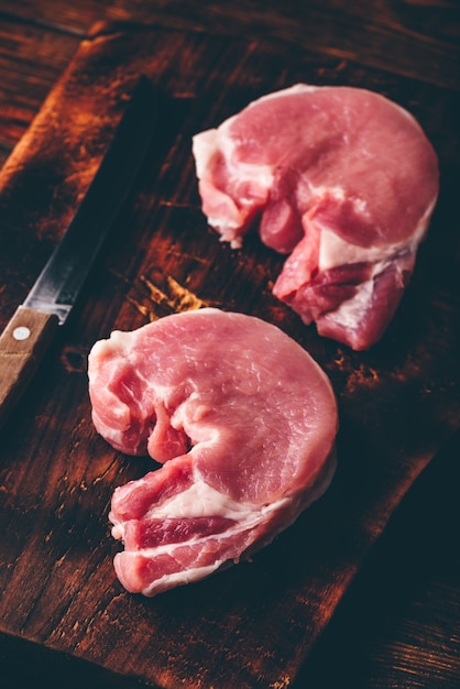 Dos filetes de lomo de cerdo con cuchillo sobre tabla de cortar rústica