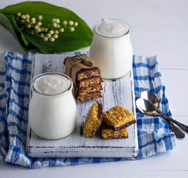 Dos frascos con yogur casero y aperitivos de muesli.