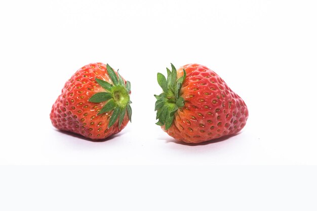 Dos fresas sobre un fondo blanco.