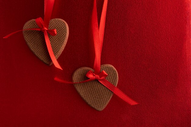 Dos galletas de jengibre en forma de corazón con cintas rojas como decoración. Día de la Madre. Día de la Mujer. Día de San Valentín.