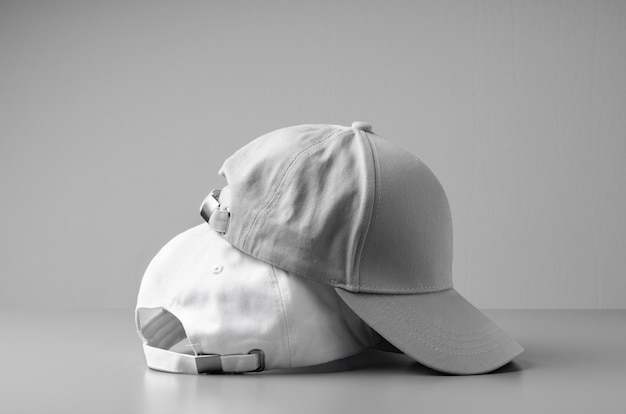 Dos gorras de béisbol blancas sobre un fondo blanco