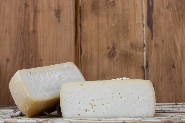 Foto dos grandes cabezas de queso orgánico en madera