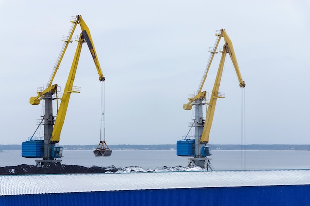 Dos grandes grúas portuarias en un almacén de carbón y un muelle en el golfo