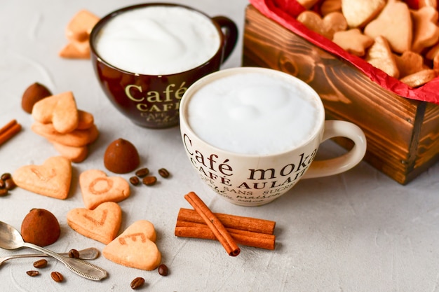 Dos grandes tazas de café y galletas en forma de corazones. desayuno romántico, romántico día de San Valentín