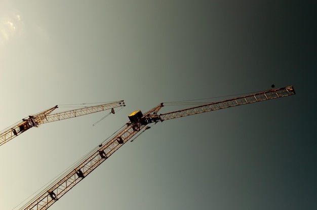 Dos grúas de construcción contra el cielo del atardecer