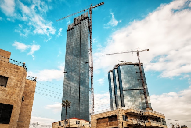 Dos grúas de gran altura construyen un rascacielos. tema industrial