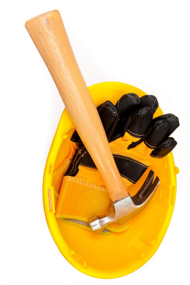 Foto dos guantes de cuero y un martillo acostado en un casco