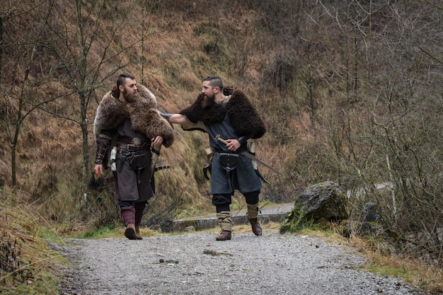 Foto dos guerreros caminando por el bosque.