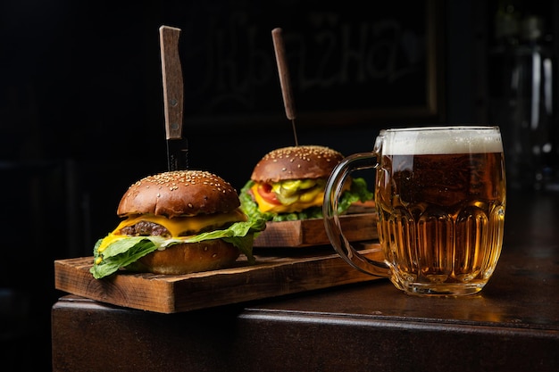 Dos hamburguesas con una jarra de cerveza sobre la mesa