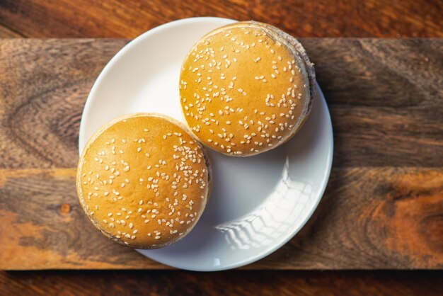 Dos hamburguesas con queso o hamburguesas en un plato sobre un fondo de madera Comida rápida