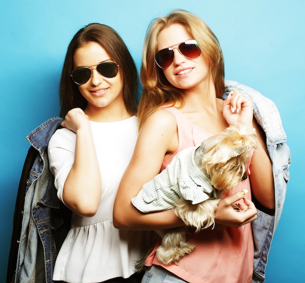 Dos hermanas adolescentes felices con Yorkshire Terrier