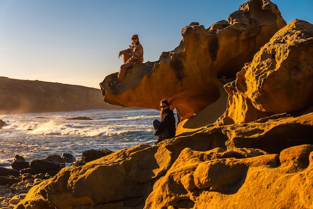 Dos hermanas al atardecer en la cala de piedra del monte Jaizkibel