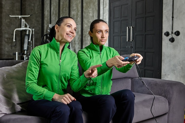 Foto dos hermanas están jugando videojuegos de cybersport con la ayuda de la consola.