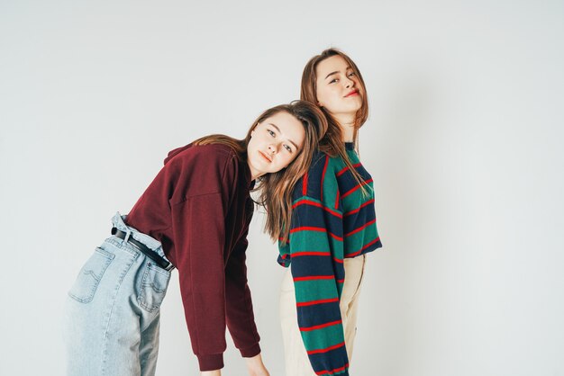 Dos hermanas gemelas hermosas chicas hipsters en ropa casual