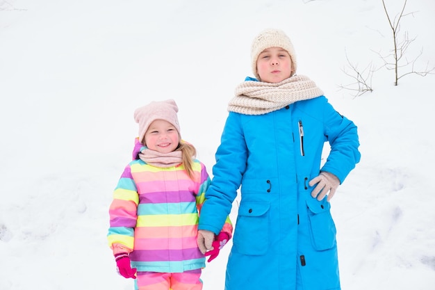 Dos hermanas juegan lindas afuera en un día de invierno