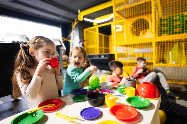 Dos hermanas jugando en la cocina para niños en el centro de juegos para niños